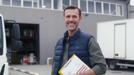 Portrait-of-caucasian-mature-man-in-front-of-warehouse.